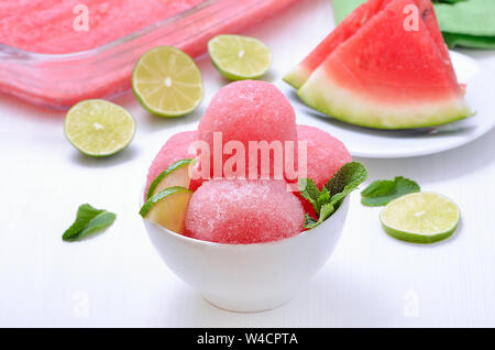 Scoop of watermelon sorbet decorated with slices of lime and mint Stock Photo