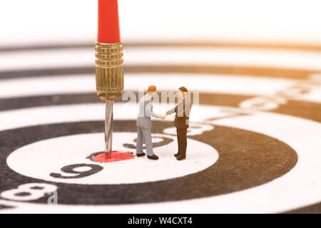 miniature people on dartboard and shecking hand,,business concept Stock Photo