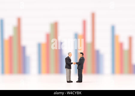 miniature people  shecking hand on business chart background,business concept Stock Photo