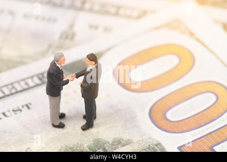 miniature people  shecking hand on us dollar banknote,business concept Stock Photo