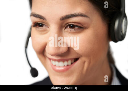 Close Up Of Businesswoman Wearing Telephone Headset In Customer Services Department Stock Photo