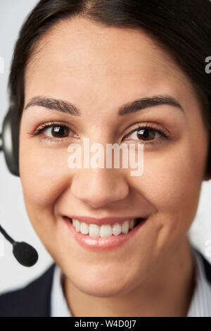 Portrait Of Smiling Businesswoman Wearing Telephone Headset In Customer Services Department Stock Photo