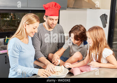 Family with two kids have fun baking bread together in the kitchen Stock Photo