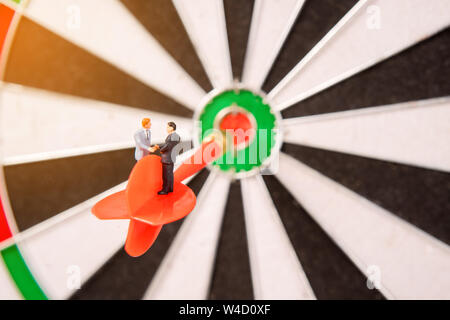 miniature people on dartboard and shecking hand,,business concept Stock Photo