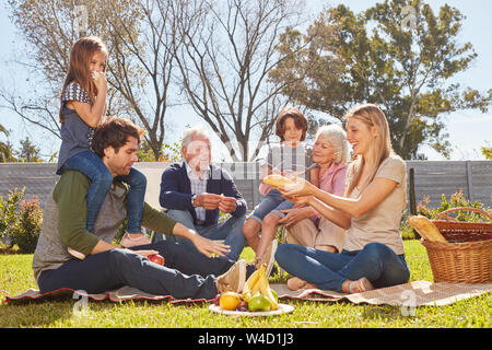 Extended family of three generations having a picnic in the garden in summer Stock Photo