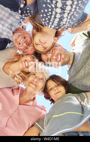 Happy extended family with three generations standing head to head in summer Stock Photo