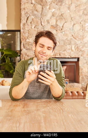 Young man using smartphone while chatting or writing a text message Stock Photo