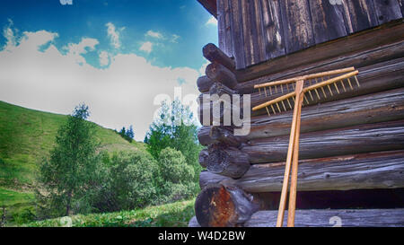 wooden rakes leaning against a barn in Alta Badia, alps Italy Stock Photo