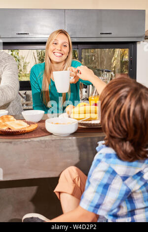 Mother and son in the morning having breakfast together at the counter in the kitchen Stock Photo
