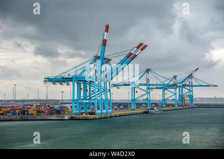Large cranes on a cloudy day at the dock in the Port of Zeebrugge in Belgium. Stock Photo