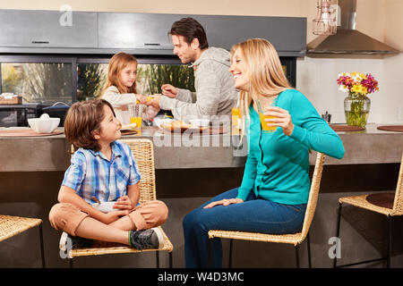 Family with two children having breakfast together in the morning in the kitchen Stock Photo