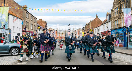 Traditional Scottish pipe band parades down High Street, Dunbar, East Lothian, Scotland, UK Stock Photo