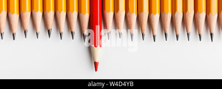Red pencil protruding out of row with classic ones Stock Photo