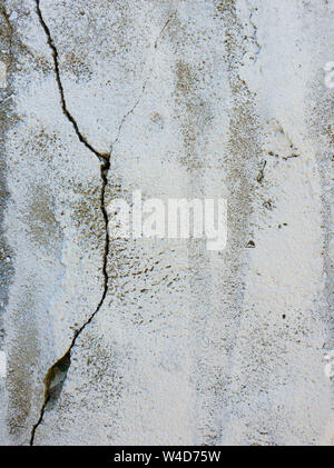 Old grungy, weathered concrete wall with big cracks. White beton structure, abstract details of construction element. Dirty texture surface. Stock Photo