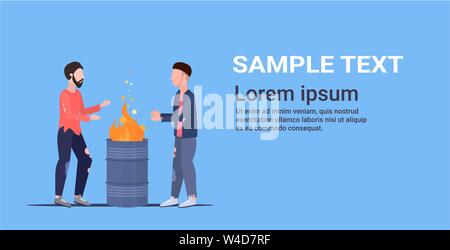 two poor men warming by fire beggars standing near burning garbage in barrel homeless jobless unemployment concept horizontal copy space flat full Stock Vector