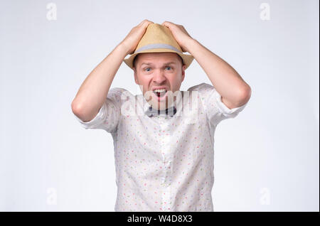 Scared man in summer hat shouting being stressed. Stock Photo