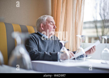 Man looking at menu in restaurant Stock Photo
