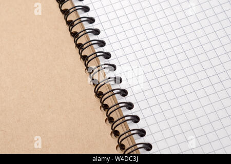 Notebook with checkered sheets on a wooden table. Close-up. Stock Photo