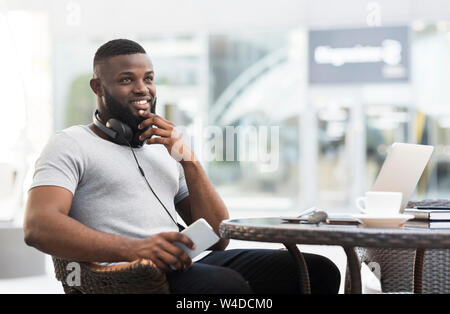 Young african man with laptop thinking about making order Stock Photo