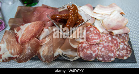 Sliced mixed Italian: Salami, raw ham, bacon and dry tomatoes. Stock Photo