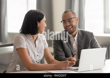 Diverse happy colleagues talking laughing working together at work break Stock Photo