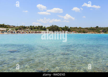 Beautiful panoramic view of Lagonisi beach at summer day . Tourist enjoy summer vacation on sand beach. Halkidiki, Sithonia , Greece. Stock Photo