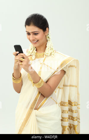 South Indian woman text messaging and smiling Stock Photo - Alamy