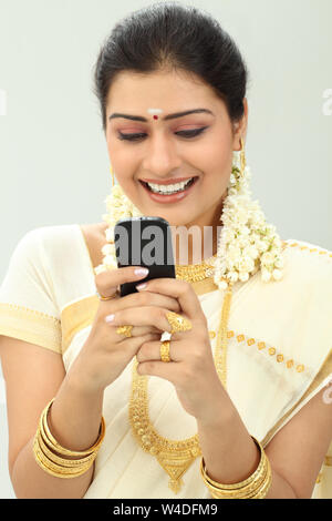 South Indian woman text messaging and smiling Stock Photo - Alamy