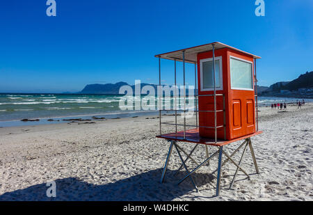 Red lifeguard station at Muizenberg beach in South Africa. Sunny day at the beach outside Cape Town. Blue Sky and good weather in summer. Stock Photo