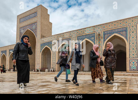 Young Uzbek women in the courtyard of Kalan Mosque (Kalon), Bukhara, Uzbekistan Stock Photo