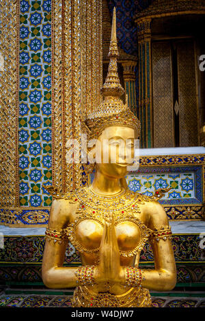 Golden figure of a half-man, half-bird called a Kinnara guards the Temple of the Emerald Buddha at the Grand Palace in Bangkok, Thailand.