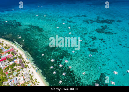 Aerial view of traditional Bangka boats moored above a large tropical coral reef in a calm ocean (Malapascua, Philippines) Stock Photo