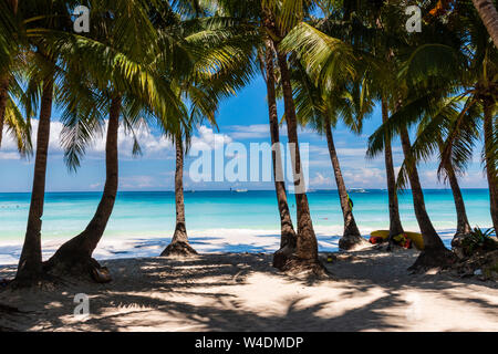 A beautiful tropical sandy beach surrounded by palm trees and warm ocean (White Beach, Boracay) Stock Photo