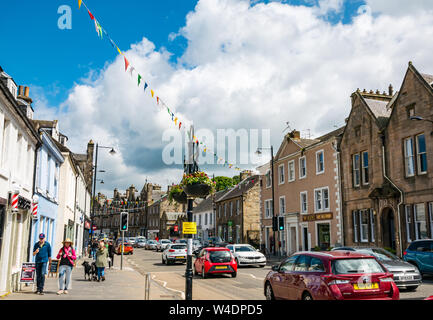 People and cars on busy High Street, Linlithgow, decorated with flags for gala day, Scotland, UK Stock Photo