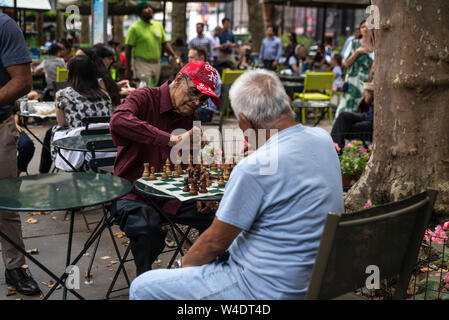 New York City, USA - August 2, 2018: Elderly people playing chess in Bryant Park, Midtown Manhattan, New York City, USA Stock Photo