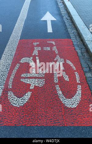 Red marked bicycle path on the roadway, Krakow, Poland Stock Photo