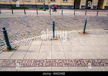 Warsaw, Poland. 22nd July, 2019. Sign on the pavement marking Ghetto wall - before March of Remembrance on the 77th anniversary of the beginning of the Warsaw Ghetto liquidation action. On July 22th, 1942, Germans began deporting residents of the Warsaw Ghetto to the Treblinka extermination camp. For more than 2 months around 5-7 thousand Jews from Warsaw and neighboring towns were transported every day in wagons to Treblinka and killed. Over 300 000 Warsaw Jews were murdered during WW2. Credit: Robert Pastryk/ZUMA Wire/Alamy Live News Stock Photo