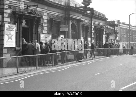 1970s, historical, people queuing outside the entrance to New Cross Station, a south-east London train station, possibly because of an overcrowded platform due to a railway workers strike common at this time. The station opened in 1850 and post WW2 became a part of British Railways. At this time, the original victoran station building on the road bridge was still in existence but later in the decade, it was replaced and moved as platforms and tracks were demolished and altered. Stock Photo