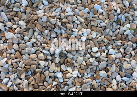 Plenty of white, grey, beige and brown pebble stones forming a lovely pastel colored surface. Very zen, spa and relaxing image. Beautiful texture. Stock Photo