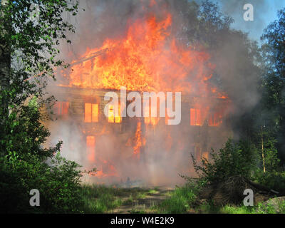 Burning house. Big wooden building completely destroyed by fire Stock Photo