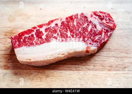 Raw rumpsteak on wooden cutting board Stock Photo