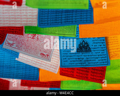 Tibetan Prayer Flags hang above a market stall Stock Photo