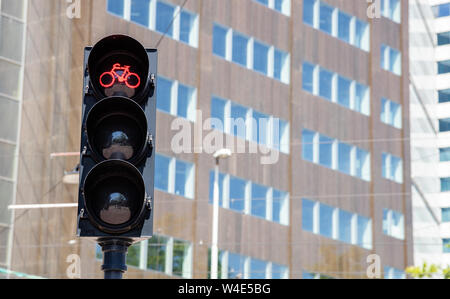 Red traffic light for cyclists against building facade background. Bicycles crossing with safety concept Stock Photo