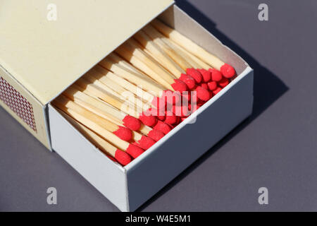 Matchsticks in a beige matchbox on gray background Stock Photo
