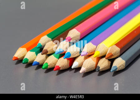 Heap of colored pencils on grey background Stock Photo