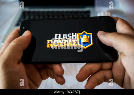Nizhyn, Ukraine/July-16-2019: Hands holding smartphone and playing Clash royale. Android gaming concept. Stock Photo