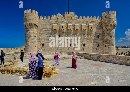 Tourists enjoy the views of Fort and city from the outer walls of Qaitbay citadel in Alexandria Egypt. Stock Photo