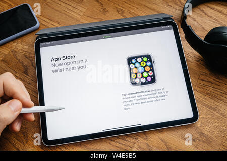 Paris, France - Jun 6, 2019: Man reading on Apple iPad Pro tablet about latest announcement of at Apple Worldwide Developers Conference WWDC - showing the App Store on watch 4 Stock Photo