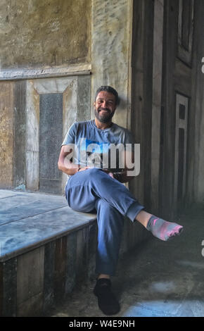 Mohamed seated in the sunlight shining through a sun window of the Al Hassan Mosque in Cairo Stock Photo