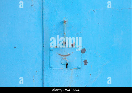 metal blue door with padlock. Old garage gates with keyhole Stock Photo